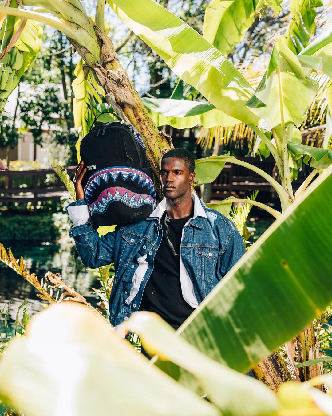 Sprayground Classic | A.I. AFRICAN INTELLIGENCE BORN AND RAISED BACKPACK - SANDFLOWER COLLAB