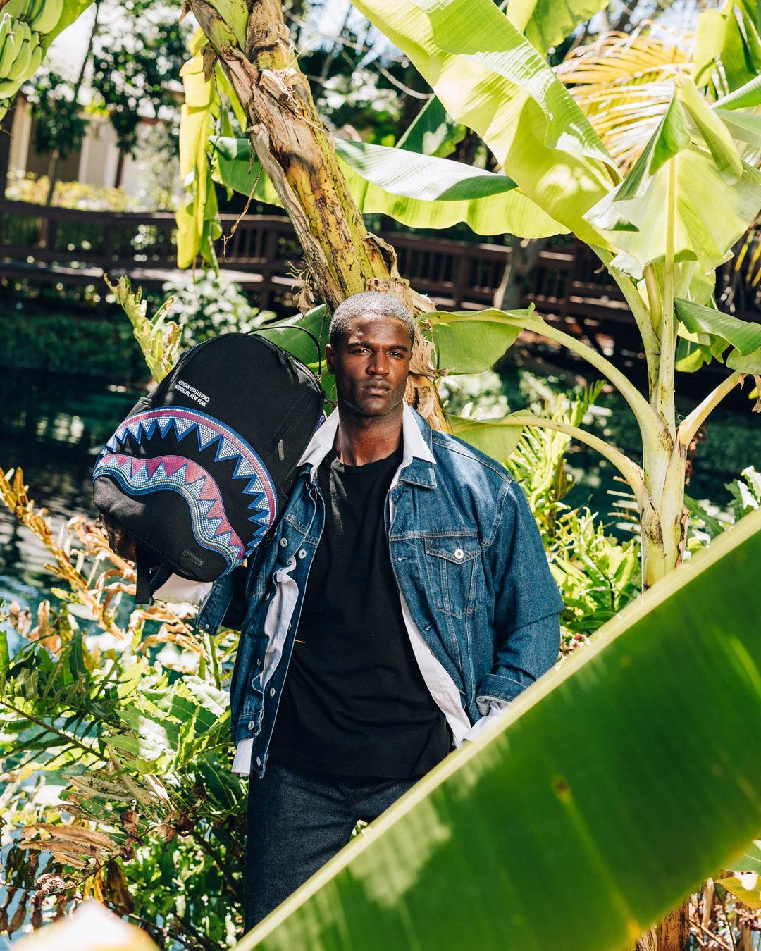 Sprayground Classic | A.I. AFRICAN INTELLIGENCE BORN AND RAISED BACKPACK - SANDFLOWER COLLAB