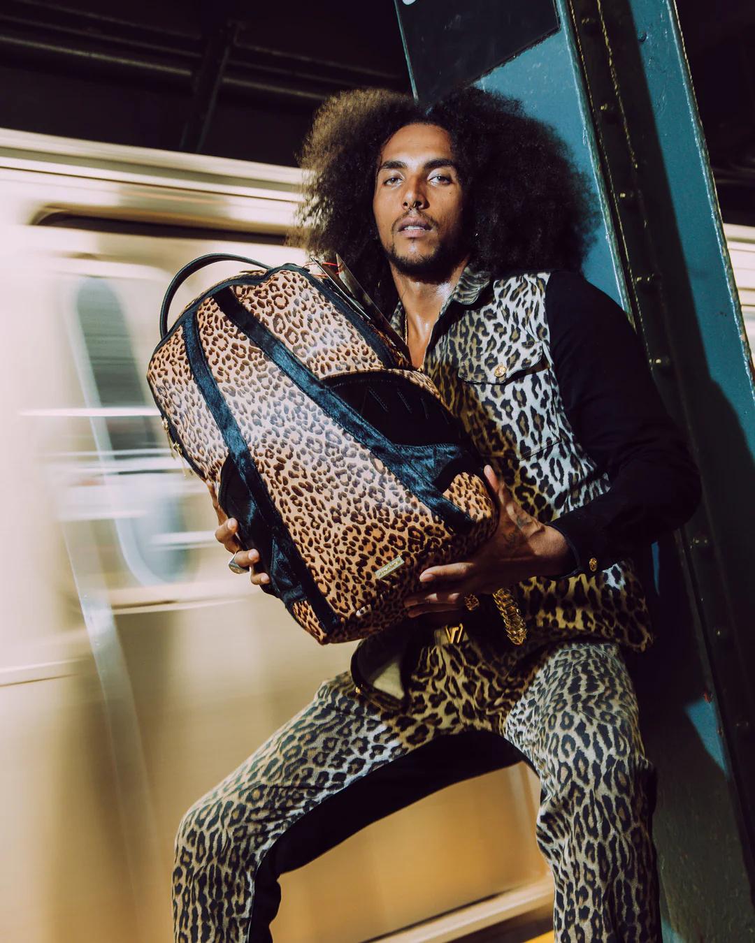 Sprayground Essential | AFRICAN INTELLIGENCE 9 COURAGE LIVES ON BACKPACK - SANDFLOWER COLLAB